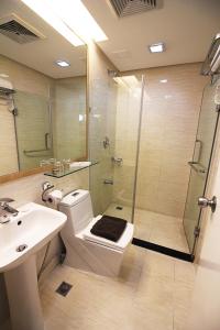 a bathroom with a shower and a toilet and a sink at BSA Twin Towers in Manila