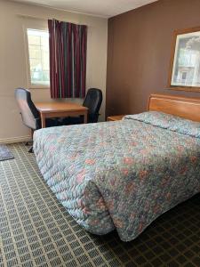 Cette chambre comprend un lit, des chaises et un bureau. dans l'établissement Aaron Motel, à Portland