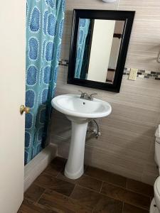 La salle de bains est pourvue d'un lavabo, d'un miroir et de toilettes. dans l'établissement Aaron Motel, à Portland