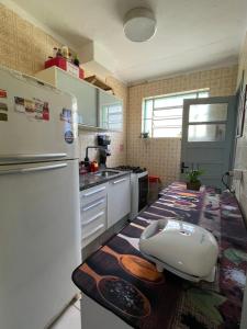 uma cozinha com um frigorífico branco e uma bancada em Apartamento familiar com estacionamento em Porto Alegre
