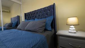 a bedroom with a blue bed with a large mirror at APARTAMENTO FRANCO in Santo Domingo