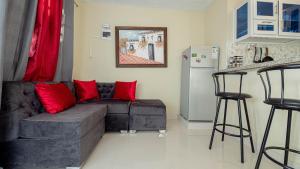 a living room with a gray couch and red pillows at APARTAMENTO FRANCO in Santo Domingo