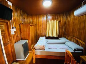 的住宿－ครัวป่าตันแอนด์โฮมสเตย์，小房间设有床和电视