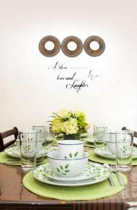 una mesa con platos y tazas y vasos. en Home away from home., en Bacolod
