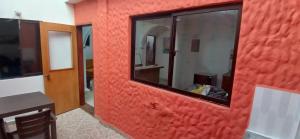 a red wall with a mirror in a room at Apartamento Rionegro cerca al Aeropuerto in Rionegro