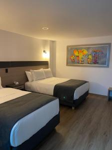 una habitación de hotel con 2 camas y un cuadro en la pared en HOTEL SALVATORE en Paipa