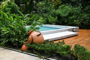 a garden with a swimming pool with aitatingificialificialificialificialificialificialificial at Coco Bungo - Beachside Bungalow #3 in Santa Teresa Beach