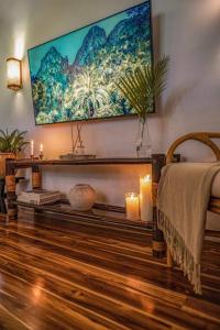 a living room with candles and a large painting on the wall at Coco Bungo - Beachside Bungalow #3 in Santa Teresa Beach