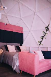 1 dormitorio con cama rosa y sofá rosa en Domo Supernova by @highlowstays en Gramado