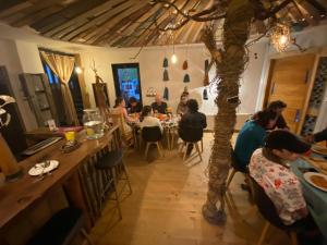 eine Gruppe von Menschen, die an einem Tisch in einem Restaurant sitzen in der Unterkunft La Colmena eco lodge in La Ensenada