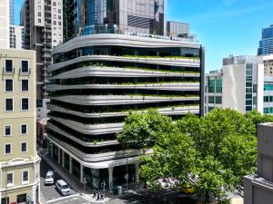 un immeuble de bureaux dans une ville avec des arbres et des voitures dans l'établissement Aspire Melbourne, à Melbourne