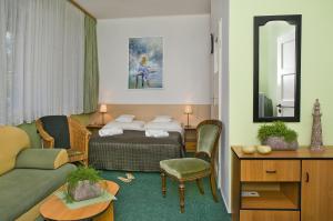 a hotel room with a bed and a couch at Dom Wypoczynkowy Helunia in Jurata
