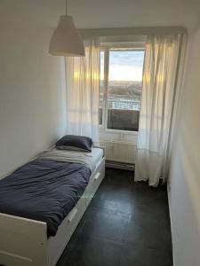 - un petit lit dans une chambre avec fenêtre dans l'établissement Appart meublé 92m2 + 2 terrasses, à Bruxelles