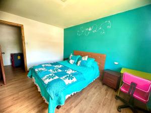 1 dormitorio con 1 cama con pared azul en Cabañas Antü 1, en Coyhaique