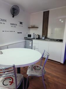 a kitchen with a white table and two chairs at Depto JJ in Las Heras