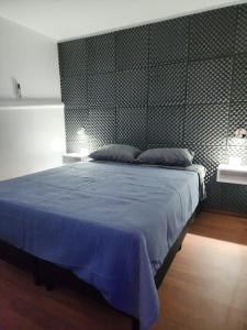 a bedroom with a large bed with a blue blanket at Depto JJ in Las Heras