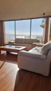 ビーニャデルマールにあるDepartamento 3h 3b Viña del Marのリビングルーム(白いソファ、大きな窓付)