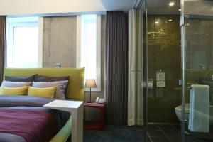 首爾的住宿－Hotel Cocomo，一间卧室设有一张床和一个玻璃淋浴间
