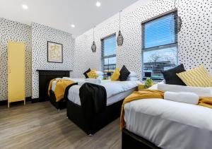 a bedroom with three beds and a fireplace in it at Bright & Colourful House - Best for a Large Groups in London