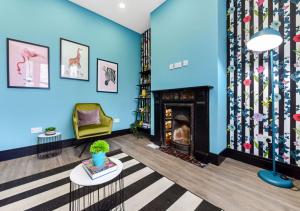 un soggiorno con pareti blu e camino di Bright & Colourful House - Best for a Large Groups a Londra