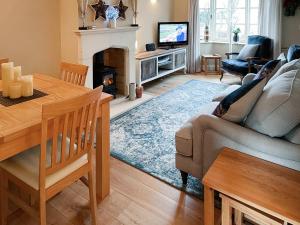 a living room with a couch and a fireplace at Bea Cottage in Bourton on the Water