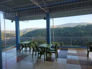 a patio with tables and chairs and a view of the mountains at Vati guesthouse in Shillong