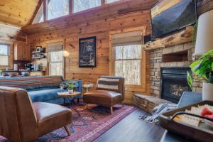 a living room with a fireplace in a log cabin at Updated Serene Mtn Cabin, theater rm & popcorn! in Sevierville