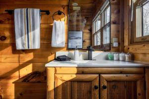a bathroom with a sink in a wooden cabin at Updated Serene Mtn Cabin, theater rm & popcorn! in Sevierville +60 photos