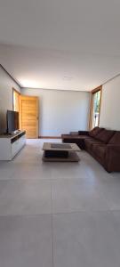 a living room with a couch and a tv at White House - Taipú de Fora in Barra Grande