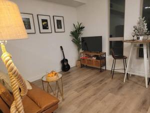 a living room with a couch and a television at Amazing big studio near Balboa Park Jacuzzi rooftop free parking! in San Diego