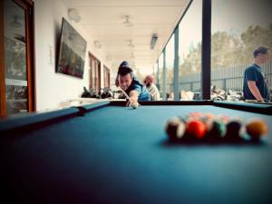 a man playing pool in a pool table at The Ocean Street House in Budgewoi