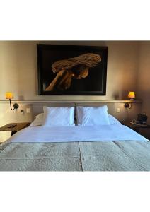 a bed in a bedroom with a picture of a woman with an umbrella at Casa Andreu in San Miguel de Allende