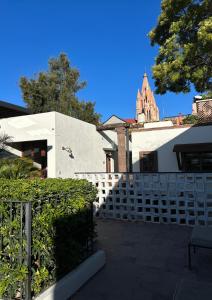 a building with a white fence and a church at Casa Andreu in San Miguel de Allende