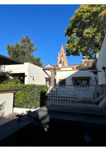 a building with a fence and a church in the background at Casa Andreu in San Miguel de Allende