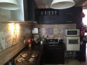 uma cozinha com um fogão e um micro-ondas em 2 quadras do mar em Vila Velha