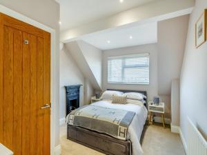 a bedroom with a bed and a window at Wharfedale Cottage in Harrogate