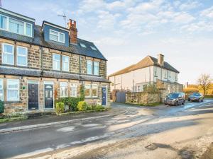 a street with two houses and cars parked on the street at Wharfedale Cottage in Harrogate