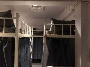 2 Etagenbetten in einem Zimmer mit schwarzen Kissen in der Unterkunft Phi Phi Green House & Sunsky Hostel in Ko Phi Phi