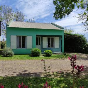 una casa verde con un verde di Alojamiento Dimar a Villa Elisa