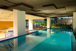 a swimming pool in a building with a hotel at Aloft Jakarta Wahid Hasyim in Jakarta