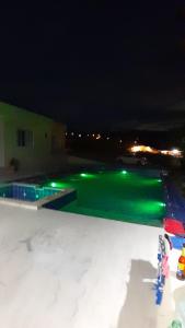 una piscina por la noche con luces verdes en CASA QUINTA BELLO HORIZONTE, en La Mesa