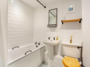 a white bathroom with a sink and a tub and a toilet at East Tarrel Cottage in Portmahomack