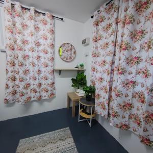 um quarto com duas cortinas com flores cor-de-rosa em Pak Long Man Roomstay em Pendang