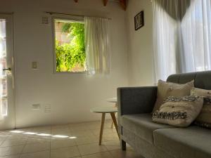 uma sala de estar com um sofá e uma janela em La calma em Puerto Madryn
