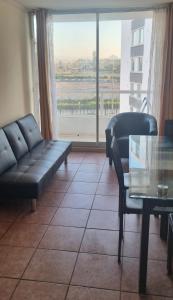 a living room with a couch and a table and a window at Arriendo departamento La Serena, sector el faro in La Serena