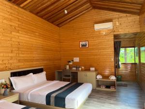 a bedroom with a bed and a desk in a room at Coconut Garden Resort 椰苑星辰 in Semporna
