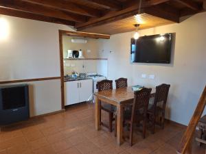cocina y comedor con mesa y sillas en Departamentos Temporarios Cabañas Ushuaia en Ushuaia