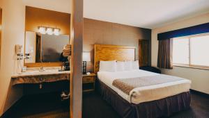 una camera d'albergo con un letto e un lavandino di Wrangler Inn Mobridge a Mobridge Altre 13 foto