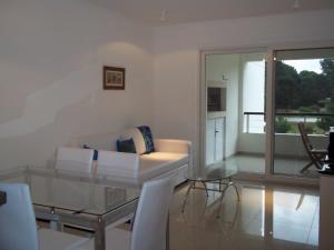 a living room with a couch and a glass table at Green Park Punta del Este - Full Amenities in Punta del Este