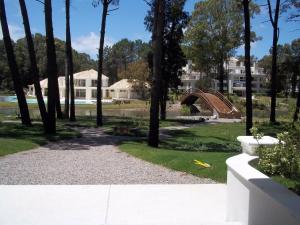un parc avec un pont et quelques arbres et maisons dans l'établissement Green Park Punta del Este, à Punta del Este